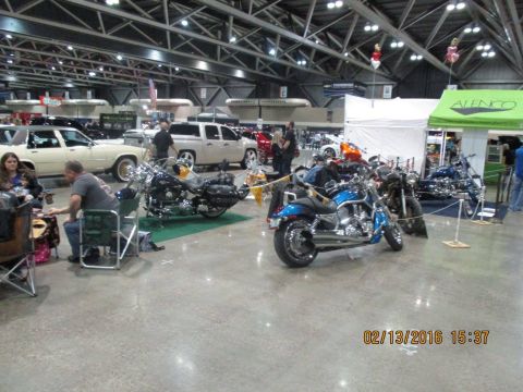 2004 Ford Crown Victoria - Indoor display of multiple motorcycles with cars and people visible in the background.
