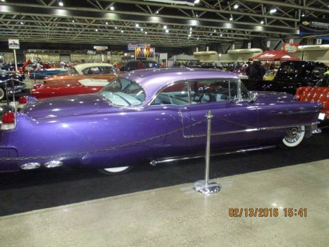 2004 Ford Crown Victoria - A purple classic car is displayed indoors with other vehicles and booths in the background.
