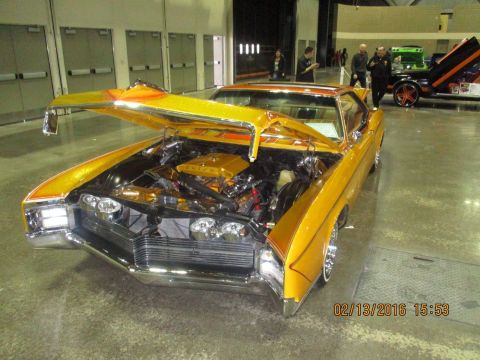 2004 Ford Crown Victoria - Customized classic car with hood open, seen at an indoor event with other vehicles present.