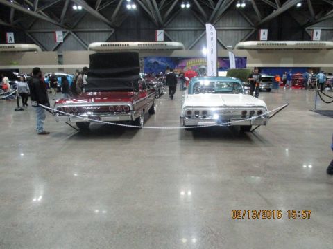 2004 Ford Crown Victoria - Two vintage cars are displayed indoors, with a date stamp of 02/13/2016 visible.