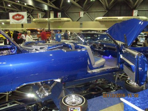 2004 Ford Crown Victoria - A custom blue convertible lowrider is displayed with its doors and hood open, its interior and modifications.