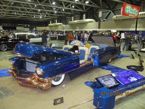 2004 Ford Crown Victoria - A custom 1950s Cadillac convertible is displayed indoors with its hood open, revealing the engine and interior.