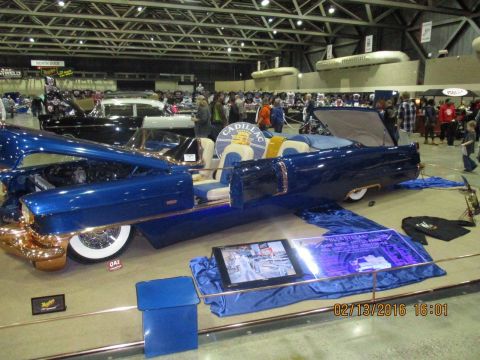 2004 Ford Crown Victoria - A custom blue convertible with gold accents is displayed indoors with its hood open.