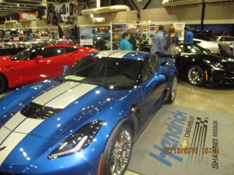 2004 Ford Crown Victoria - A blue Chevrolet Corvette with silver racing stripes is displayed at an event, with other Corvettes visible in the background.