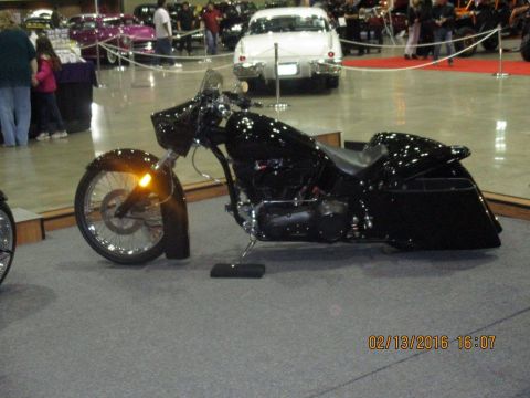 2004 Ford Crown Victoria - A black custom motorcycle is displayed indoors, with other vehicles visible in the background.