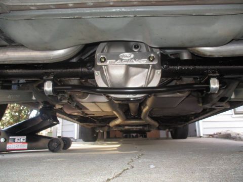 2004 Ford Crown Victoria - The rear axle assembly and exhaust system of a vehicle are shown from underneath, with a Ford Racing differential cover.