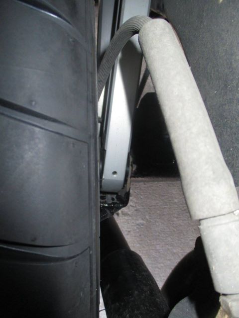 2004 Ford Crown Victoria - A close-up view of a vehicle's tire and suspension system reveals various mechanical components.