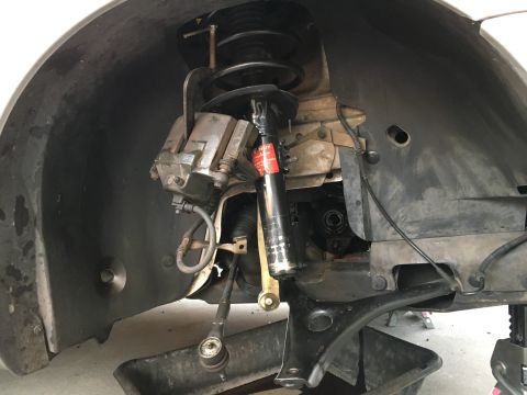 2003 Ford Taurus - Front suspension components, including brake caliper and strut, are shown with an oil drain pan below.