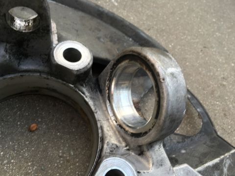 2003 Ford Taurus - A close-up view of a worn metal suspension part, possibly a control arm or knuckle, showing a bearing race.