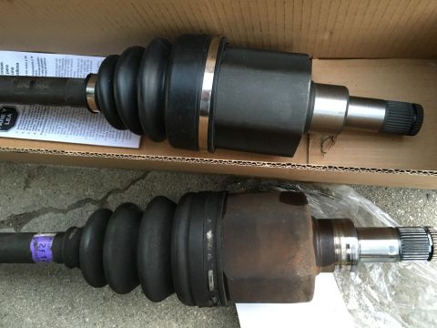 2003 Ford Taurus - Comparison of a new CV axle with an old, worn one. Both have protective rubber boots.
