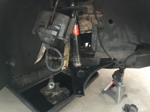 2003 Ford Taurus - Close-up of a vehicle's front suspension system, showing various mechanical parts and a drain pan.