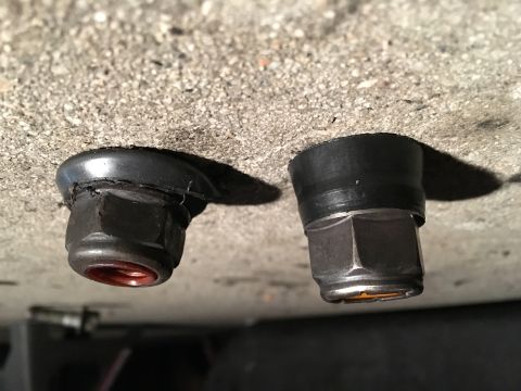 2003 Ford Taurus - Close-up view of two bolts with rubber grommets, likely part of a vehicle's suspension system.