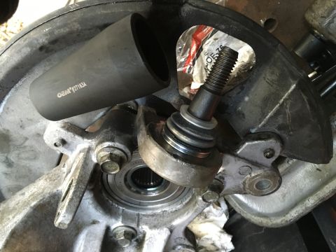 2003 Ford Taurus - Close-up of a ball joint and associated suspension components, with a specialized tool nearby.