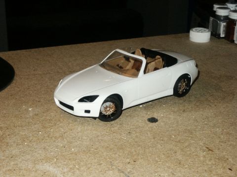1998 Mercury Sable - A white model car sits on a workbench, possibly a hobby project.