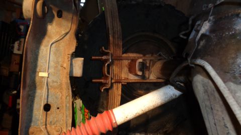 1985 Ford Bronco - The image shows a close-up view of the rear suspension system, including leaf springs and a shock absorber.