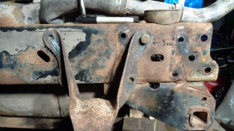 1985 Ford Bronco - Close-up view of heavily rusted vehicle frame components and suspension parts.