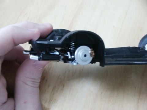1998 Mercury Sable - A hand holds a section of a model car chassis, showing suspension and brake details.