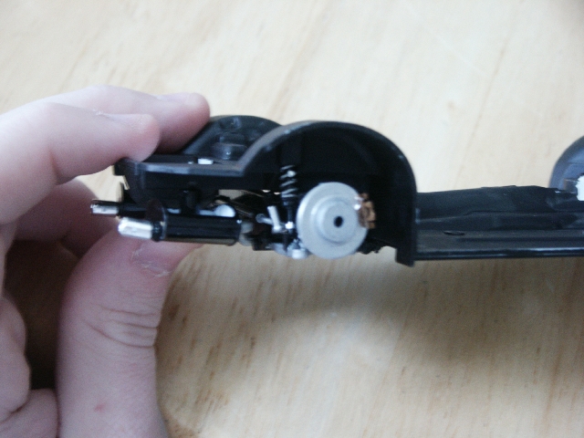 Model car chassis section with suspension components, held by a hand