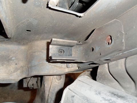 1990 Ford Bronco - Close-up of the undercarriage shows structural components and a tire.
