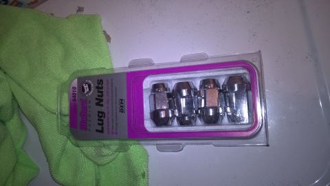 2004 Ford Crown Victoria - A package of four chrome lug nuts is shown next to a green cloth.