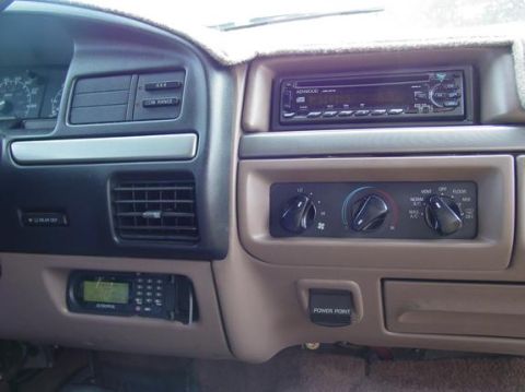 1995 Ford Bronco - Interior view of a 1995 Ford Bronco dashboard, showing the center console with various controls and accessories.