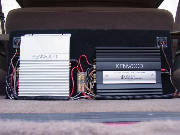 Two Kenwood amplifiers, one silver and one black, wired together