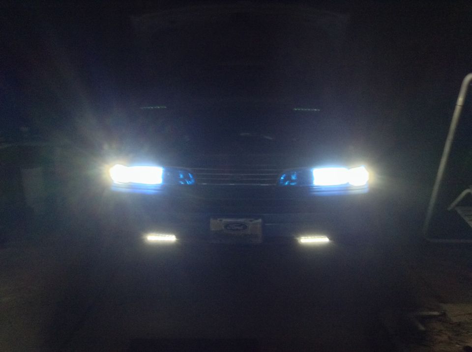 Front view of a 1994 Ford Crown Victoria with headlights on