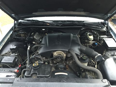 1994 Ford Crown Victoria - The engine bay of a 2000 Ford Crown Victoria is visible with the hood open, revealing the V8 engine and associated components.