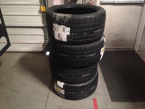 2010 Dodge Challenger - Four Mickey Thompson Street Comp tires are stacked in a garage setting.