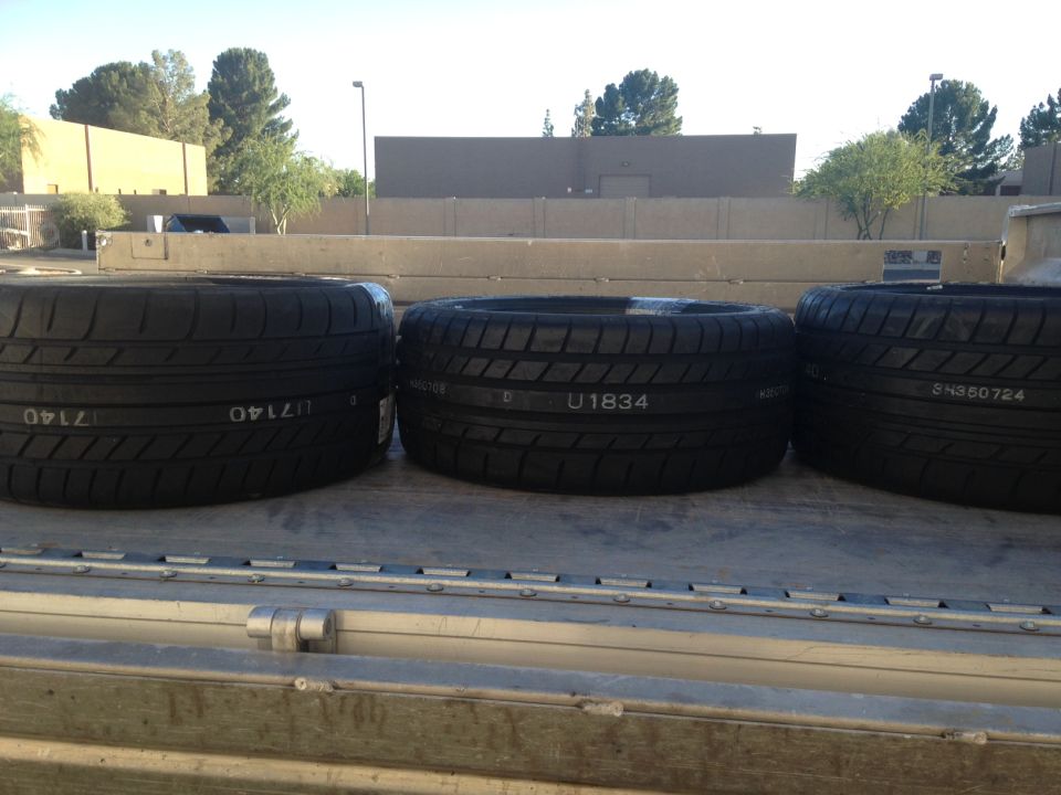 Three tires stacked on a flatbed truck. Text on tires reads "U1834" and "SN350724"