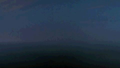 1995 Mercury Grand Marquis - A dark, hazy landscape with rolling hills under a cloudy sky.