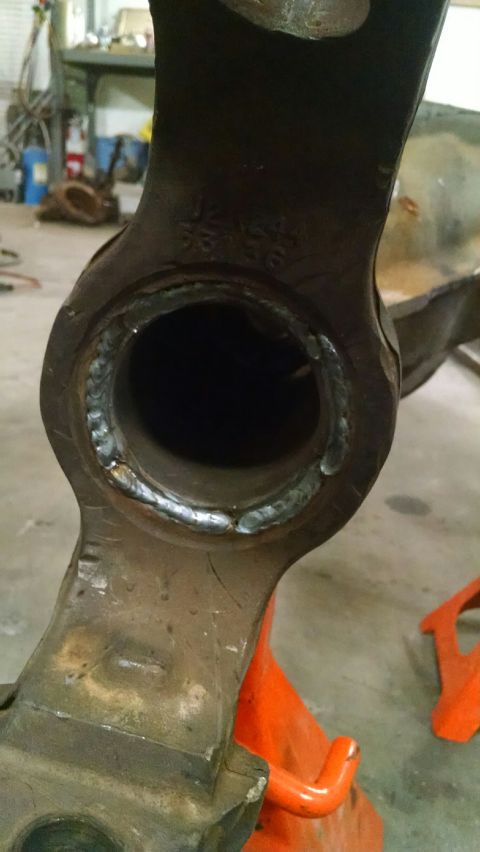 1979 Ford Bronco - A close-up view shows a heavily rusted metal automotive part with visible welding around a circular opening. The part is resting on an oran…
