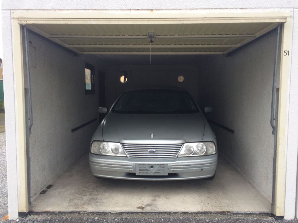 Silver sedan parked in a garage, front view.