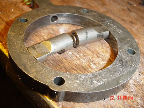 1987 Ford Bronco - Close-up of a metal mechanical part with a rotating shaft and a brass insert, resting on a wooden surface.