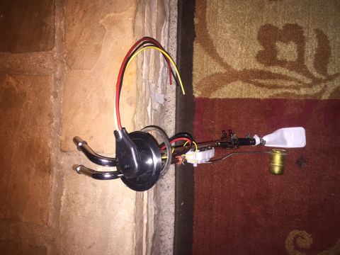 1982 Ford Bronco - A fuel pump sending unit assembly with a fuel filter and float is laid out on a carpeted surface next to a stone wall.