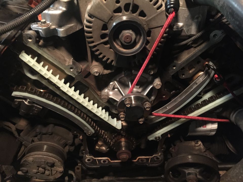 New guides, tensioner and water pump, installed, was waiting for tensioner to arrive so bungee kept tension on the chain to prevent the chain from slipping.