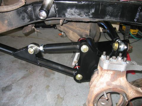 1981 Ford Bronco - A close-up view of the suspension components of a modified vehicle, likely a 1981 Ford Bronco, showing a black tubular control arm assembly…