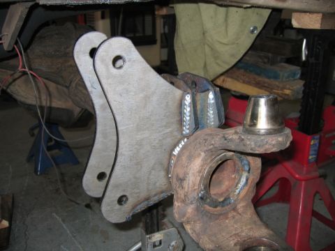 1981 Ford Bronco - A close-up view of custom fabricated suspension components, likely for a 1981 Ford Bronco, showing welded metal brackets attached to a stee…