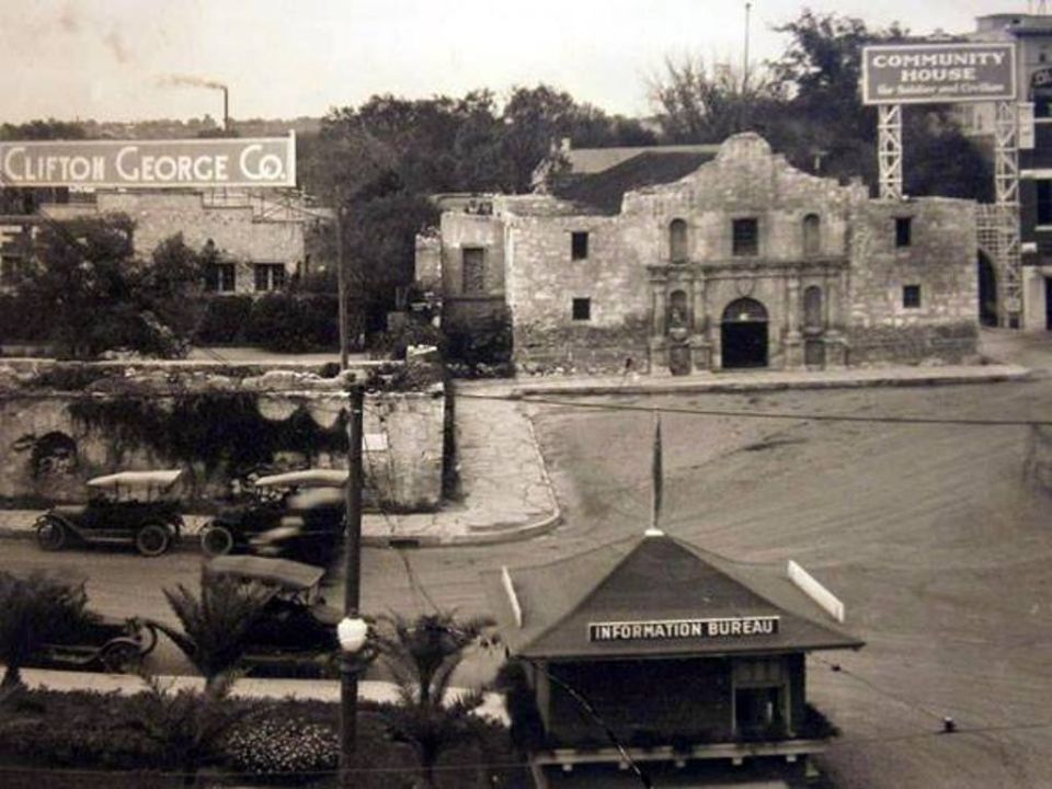 Three vintage automobiles parked on a street in front of the Alamo