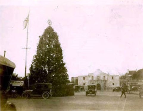 1909 Ford Model T - A street scene in front of the historic Alamo mission, with several early 20th-century automobiles visible.