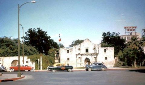 1909 Ford Model T - A street scene in front of the historic Alamo, with several vintage automobiles and the Crockett Hotel in the background.