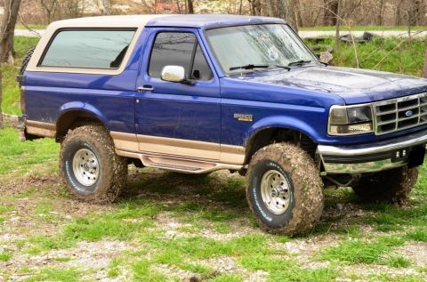 1996 Ford Bronco - This blue 1996 Ford Bronco features tan trim and a removable top, captured in a 3/4 front view.
