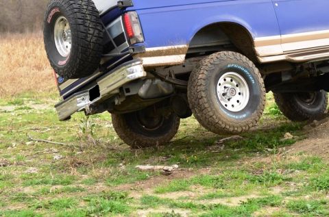 1996 Ford Bronco - Blue 1996 Ford Bronco navigating rough terrain with another vehicle nearby.