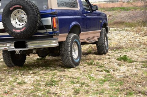 1996 Ford Bronco - This 1996 Ford Bronco is shown from the rear, equipped with a spare tire and off-road tires, suggesting it is ready for terrain.