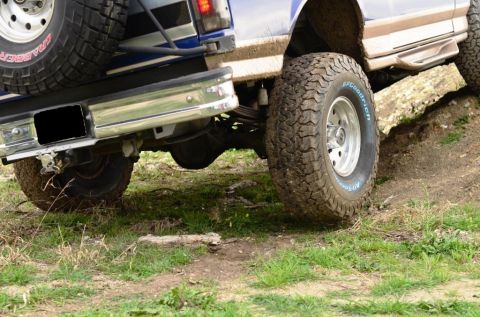 1996 Ford Bronco - Two off-road vehicles, including a 1996 Ford Bronco, navigate rough terrain.