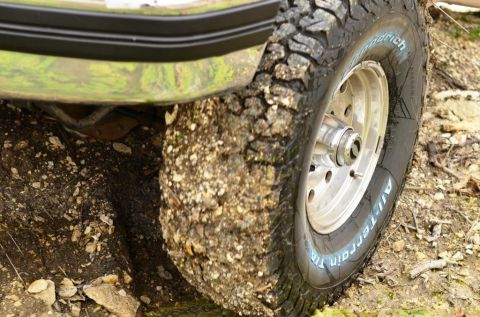 1996 Ford Bronco - A close-up view of a muddy off-road tire and fender, suggesting off-road use.