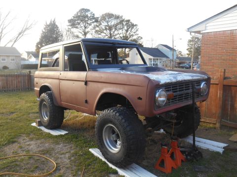 1972 Ford Bronco - This lifted Ford Bronco appears to be undergoing restoration, with its body showing significant rust and primer.