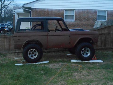 1972 Ford Bronco - This classic Ford Bronco, likely from the early 1970s, is shown in a side profile, resting on blocks in a yard.
