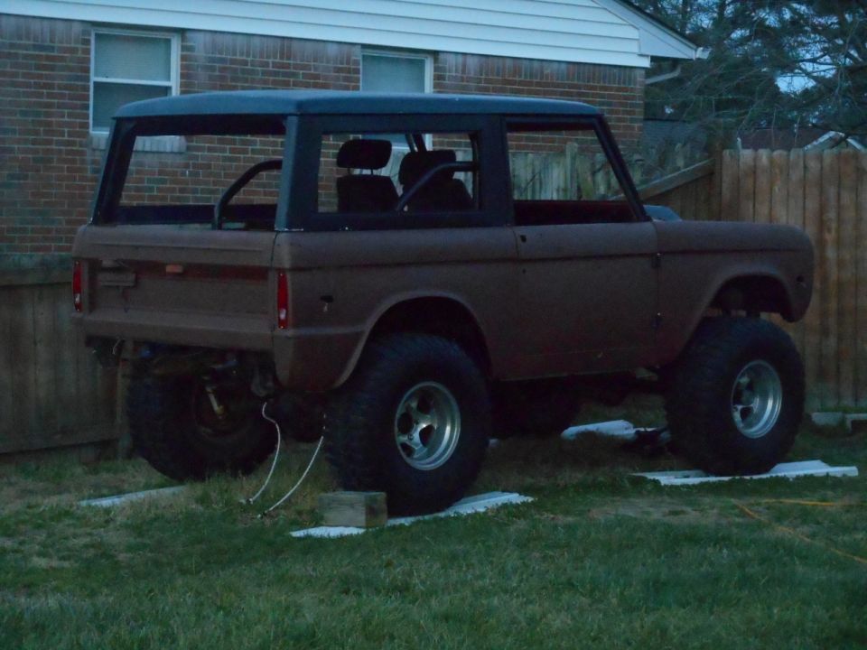 Brown 1972 Ford Bronco with black hardtop, lifted on large tires