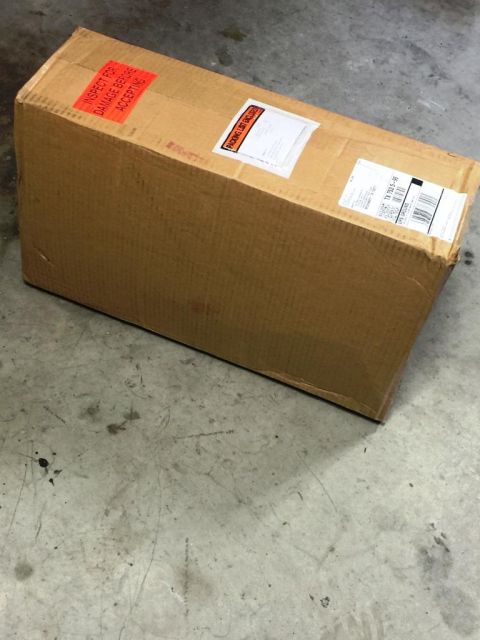 1996 Ford Bronco - Cardboard box with shipping labels and a damage inspection warning sticker.